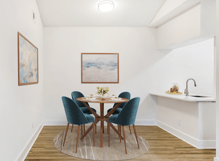 VIrtually staged diningroom with wood table, green chairs, wood style flooring, accent rug, wall art and white quartz countertop on breakfast bar